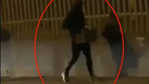 Psni man carrying crate of petrol bombs