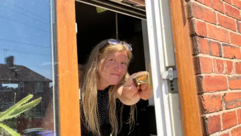 A woman peering out of a window