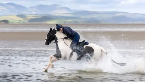 Rod Kirkpatrick/RKP Photography Rider lowers head to avoid spray from crossing through water