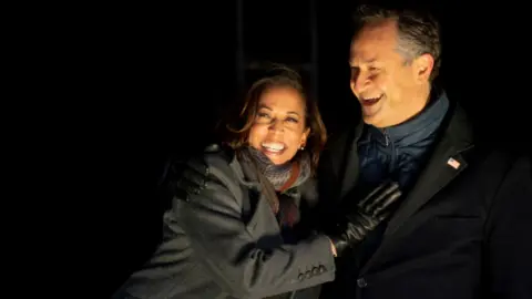 Getty Images Democratic vice presidential nominee Sen. Kamala Harris (D-CA) and husband, Douglas Emhoff, embrace on stage after Democratic presidential nominee Joe Biden spoke in Pittsburgh at a simultaneous drive-in election eve rally on November 2, 2020 in Philadelphia, Pennsylvania