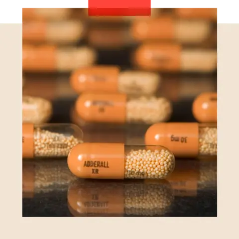 Getty Images Adderall pills in a pill container on a table