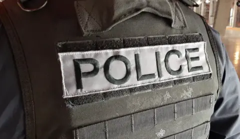 VIENNE POLICE Close-up of a  Vienne Police officer's bullet-proof vest featuring a label reading 'Police'