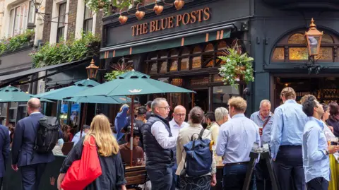 People standing and drinking outside The Blue Posts pub