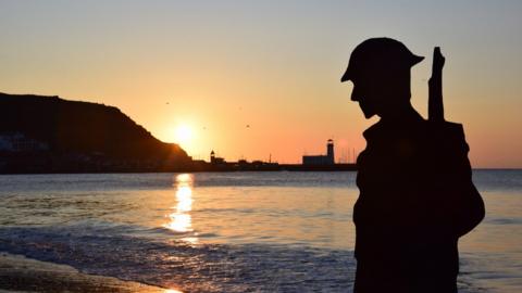 A cardboard sculpture of a soldier, pictured at sunrise on Scarborough’s South Bay