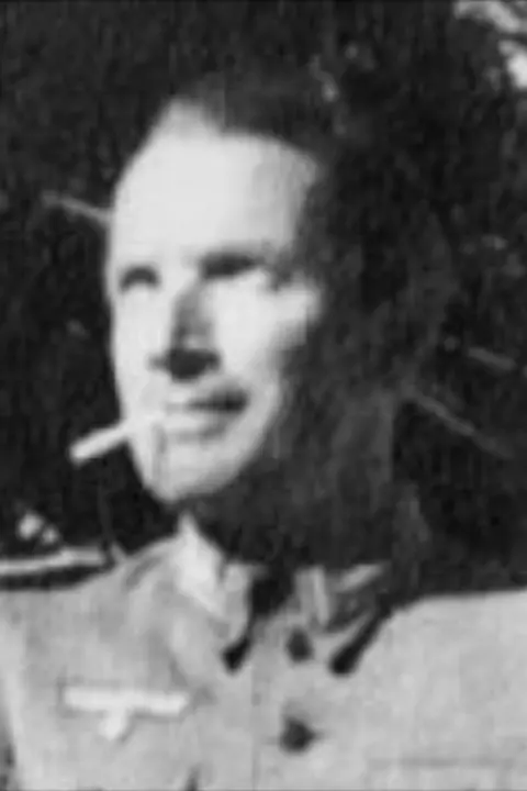 A black and white picture of Baron Von Aufsess, he is wearing German military uniform and a has a cigarette in his mouth. 