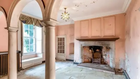 Robinson Hornsby An interior image of a Georgian manor house with a fireplace and bare walls