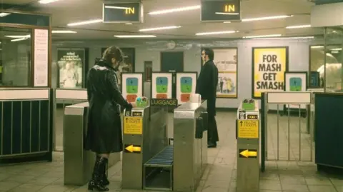 Female passenger passing through an automatic ticket gate, Seven Sisters Underground station, Victoria line, by Dr Heinz Zinram in 1969