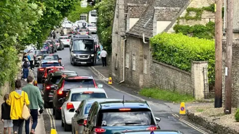 BBC Cars parked along street in Bibury