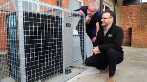 Katie Pugh Councillor Paul Drake-Davis and John Jackson, of Ideal Heating, with one of the new heat pumps at flats in Hull