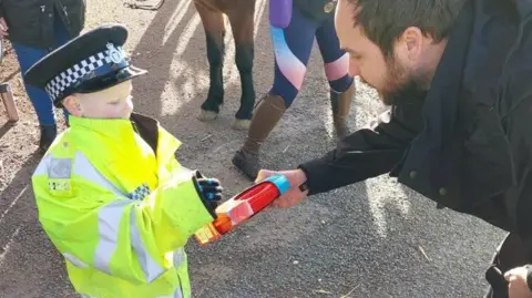 Norfolk Police A policeman giving Kodie some police Playmobile. 