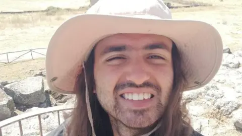 Family handout A man wearing a cream coloured sun hat smiles into the camera