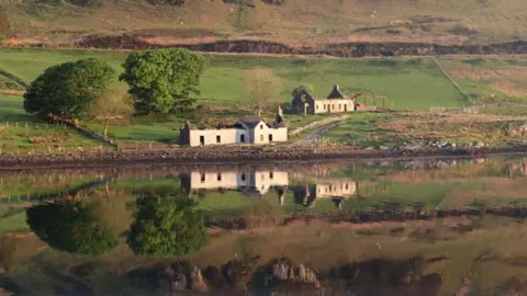 Three derelict cottages on a hillside on the banks of the Amar River on the Isle of Skye.