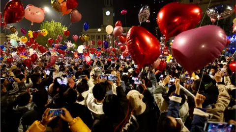 Reuters People in Wuhan, China, release balloons as they gather to celebrate amid a rise of Covid-19 cases in the country