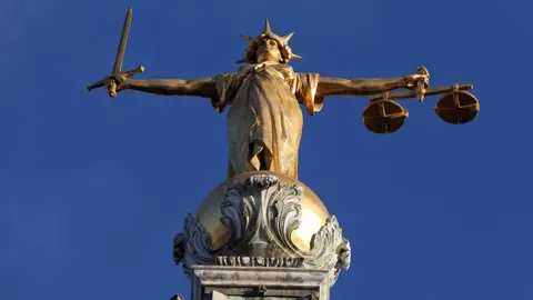 PA Media Gold statue of justice on the roof of the Old Bailey in London she holds a sword in one hand and scales in the other