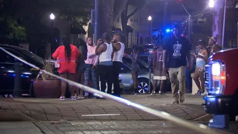 AP People stand at the scene of a mass shooting in Birmingham, Alabama