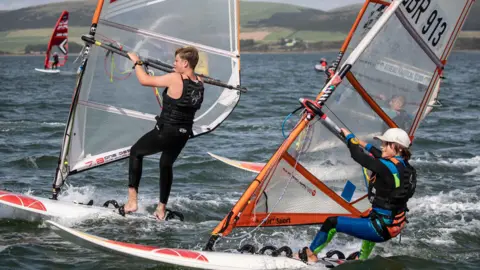 Mike Pringuer Two people on windsurfing boards in the bay at Loch Ryan