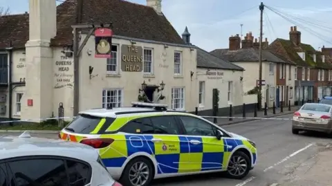 A police car and tape in front of The Queens Head pub in Boughton-under-Blean