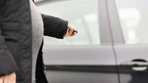 Getty Images Pregnant woman and her car