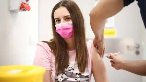 Reuters A person receives a dose of the Pfizer BioNTech vaccine at the Central Middlesex Hospital in London