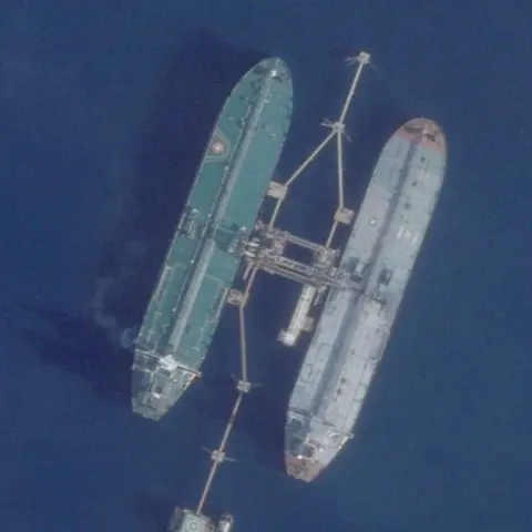 Planet Labs PBC / Reuters Two large oil tankers are connected side by side at sea 