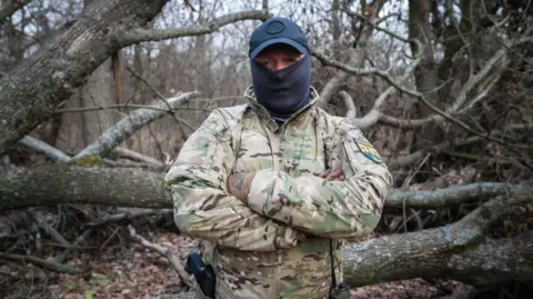 BBC/Matthew Goddard A man in a Ukrainian uniform with a balaclava and cap