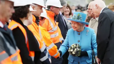 PA The Queen speaks to workers