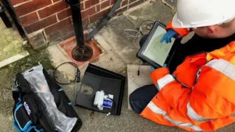Yorkshire Water Field engineer checking data from device