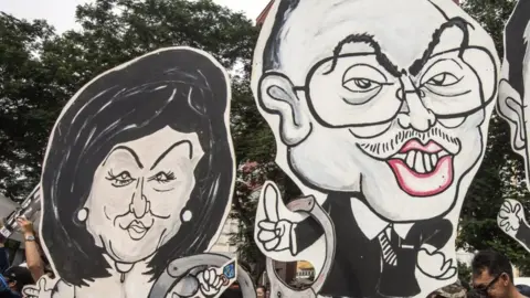 EPA A caricature of Malaysian Prime Minister Najib Razak and his wife