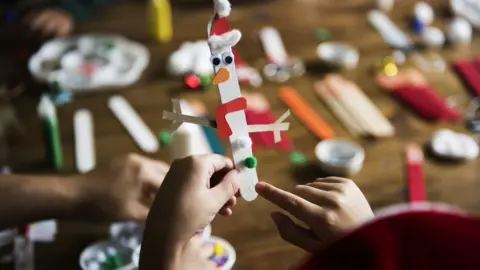 AFP Child hands hold a homemade Christmas decoration