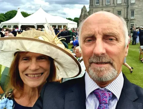 PA Media John Anderson and wife Margaret at a garden party at the Palace of Holyroodhouse