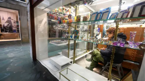 Reuters Flood and woman in shop, 15 Nov 19