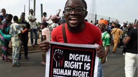 AFP A man carries a banner during a demonstration at Ojota in Lagos on June 12, 2021, as Nigerian activists called for nationwide protests over what they criticise as bad governance and insecurity, as well as the recent ban of US social media platform Twitter by the government of President Muhammadu Buhari.