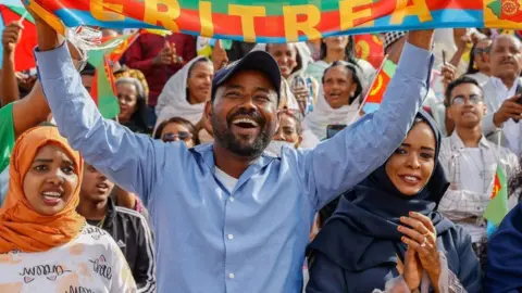 Getty Images Attendees of the official 32nd Anniversary of Independence celebration wave flags and dance during the celebration at Asmara Stadium on May 24, 2023 in Asmara, Eritrea