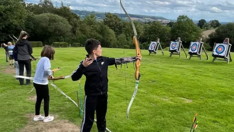 RAF Benevolent Fund A boy shooting a bow and arrow at an archery target