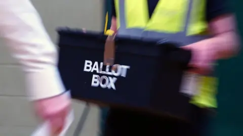 PA Media A ballot box being carried in to a count
