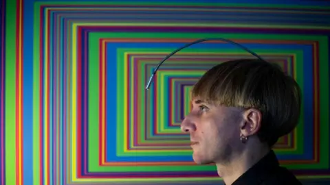 Getty Images Neil Harbisson with a work of art featuring colorful rectangles