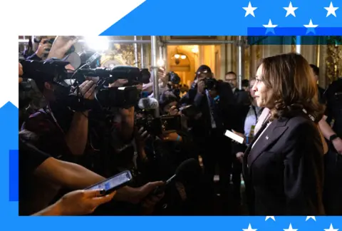 Kamala Harris photographed with a slew of journalists surrounding her 