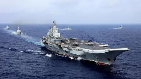 A 2018 photo of the Chinese aircraft carrier Liaoning in the western Pacific Ocean taking part in a military drill, with other military vessels surrounding it