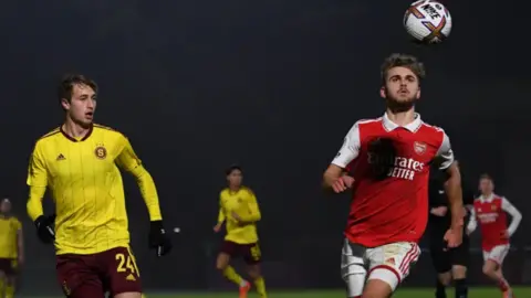 Getty Images Billy Vigar fue visto aquí en el partido contra Esparta Praga en 2022. Billy, en el kit rojo y blanco del Arsenal, está mirando la pelota en el aire. 