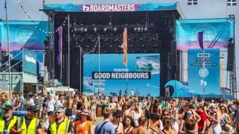 Getty Images The main stage at Boardmasters in the sunshine, the stage is pale blue and reads 'Boardmasters' at the top in purple and white writing and 'up next Good Neighbours' in the centre of it. The audience are talking as they wait for the next performance.