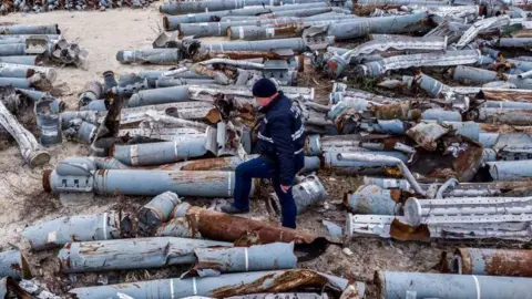 TOPSHOT - This aerial picture taken on December 7, 2022 shows an expert of the prosecutor's office examining collected remnants of shells and missiles used by the Russian army to attack the second largest Ukrainian city of Kharkiv, amid the Russian invasion of Ukraine. (Photo by Oleksii FILIPPOV / AFP) (Photo by OLEKSII FILIPPOV/AFP via Getty Images)
