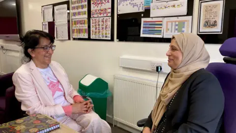 Two women talk in an office