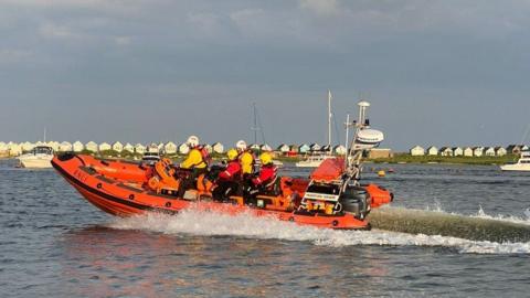 Mudeford Lifeboat with crew onboard travelling on the water
