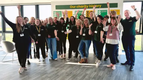 Wiltshire and Bath Air Ambulance Charity Group of people smiling and cheering inside.