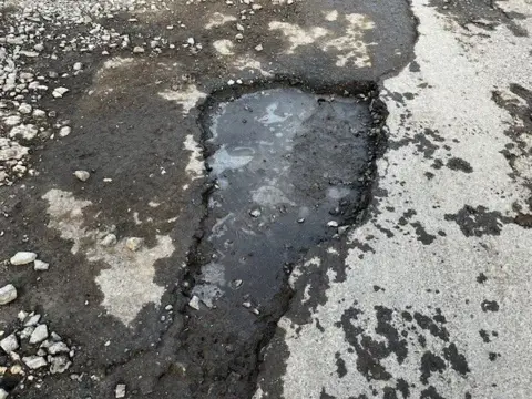 BBC / Natalie Bell A pothole in Sutterton Drove