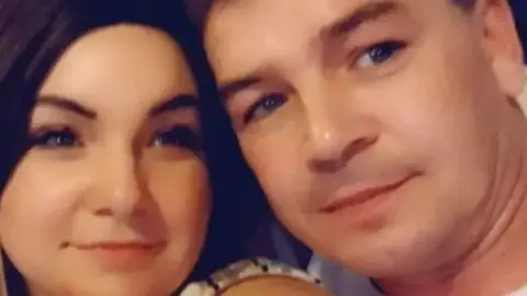 Egle Žilinskaitė in selfie with former partner. The image shows their smiling faces. She has dark hair and he has short brown hair and no facial hair. Their faces are close to each other and they are looking at the camera