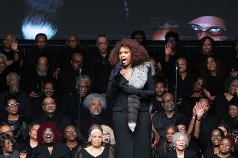 Getty Images Jennifer Hudson, wearing all black with a fur propped on her shoulder, sings at the celebration of life service for civil rights.