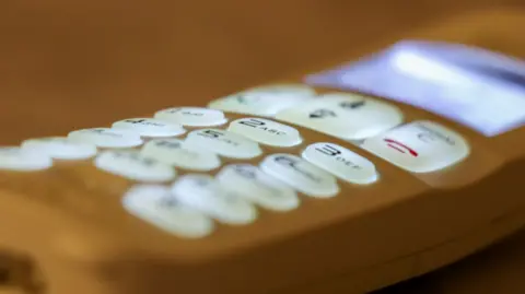 An illuminated phone with lit buttons and a lit screen.