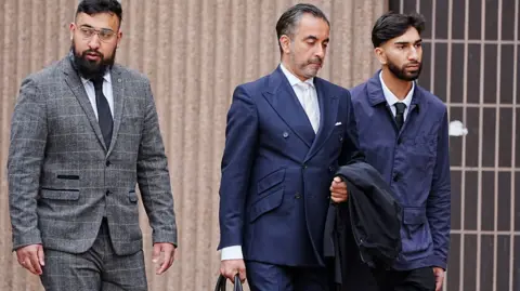 Human Rights lawyer Aamer Anwar (centre) arrives with Muhammed Amaad (left) and Mohammed Fahir Amaaz (right) at Liverpool Crown Court