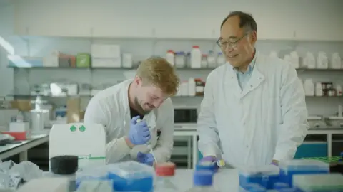 Colorifix Two men wearing white lab coats in a science lab.